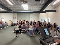 a group of people standing in front of a piano