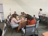 a group of people eating at a table in a room