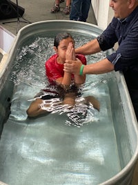 a man is baptizing a woman in a tub