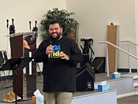 a man standing in front of a microphone in a church