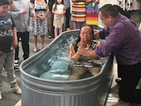 a group of people in a tub being baptized