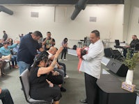 a group of people standing in a room with a man holding a baby