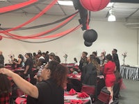 a group of people at a black and red party