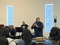 a man speaking to a group of people in a church