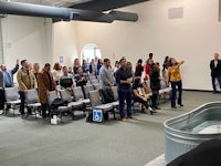 a group of people standing in a room with a tub