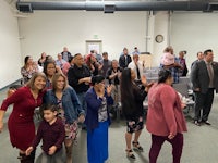 a group of people standing and clapping in a room