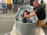 a woman is being baptized in a tub of water