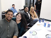 a group of people posing for a photo while sitting at a table