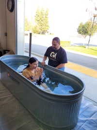 a man and woman in a tub in a garage