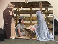 a nativity scene with three people in costumes