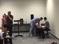 a group of people standing in front of a keyboard