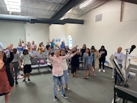 a group of people standing in a room with their hands raised