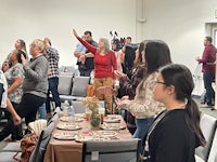 a group of people standing around a table in a room
