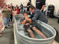 a man is being baptized in a tub