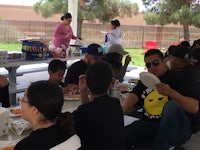 a group of people eating at a picnic table