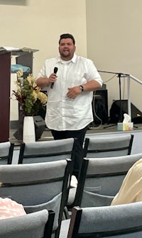 a man in a white shirt standing in front of an audience
